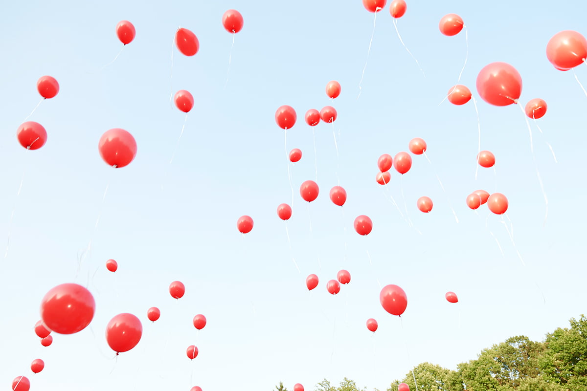 fliegende aufsteigende rote Luftballons zum Himmel auf einer Hochzeitsfeier